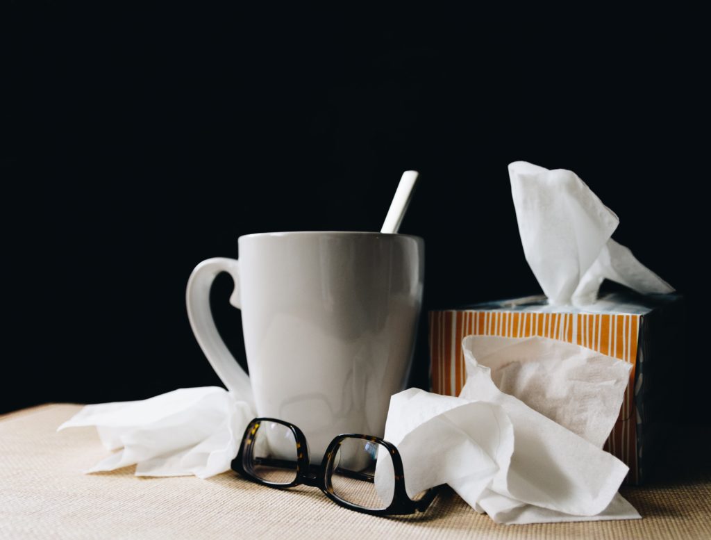 Photo of coffee cup, kleenex, and eye glasses