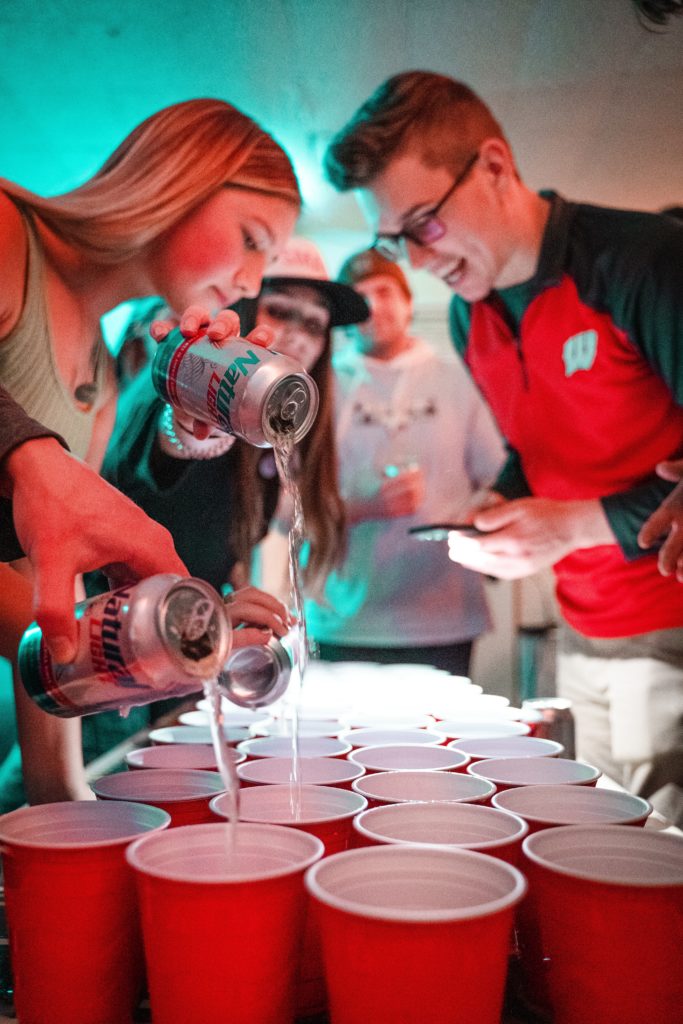 Young adults playing beer pong with red solo cups